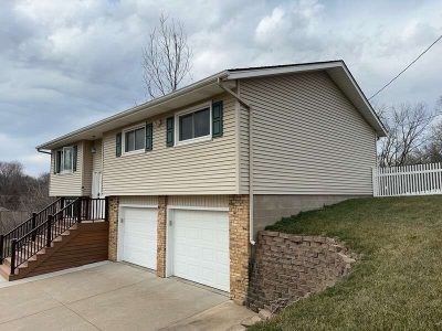 taylor ridge siding installation - front corner view of tan two-story house with two white garages, before