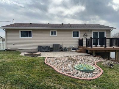 taylor ridge siding installation - backyard view of tan house with landscaping, before