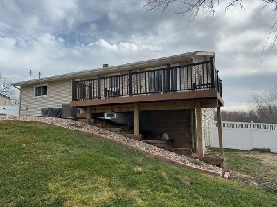 taylor ridge siding installation - backyard view of tan house with large brown deck, before