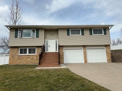 taylor ridge siding installation - street view of tan two-story house with two white garages, before