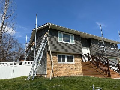 taylor ridge siding installation - ladder and contractor working on side of house, during