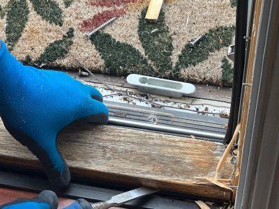geneseo window installation - worker removing old window frame, during