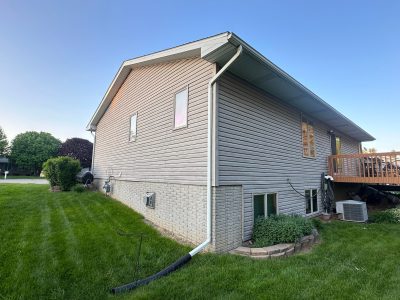 clinton siding installation - back side yard view of tan house, before