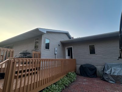clinton siding installation - back side yard view of tan house with brown deck, before