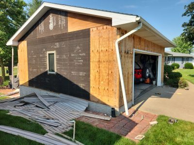 clinton siding installation - side view of garage with old siding removed, during