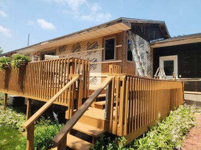 clinton siding installation - deck & back of house with siding construction layers, during